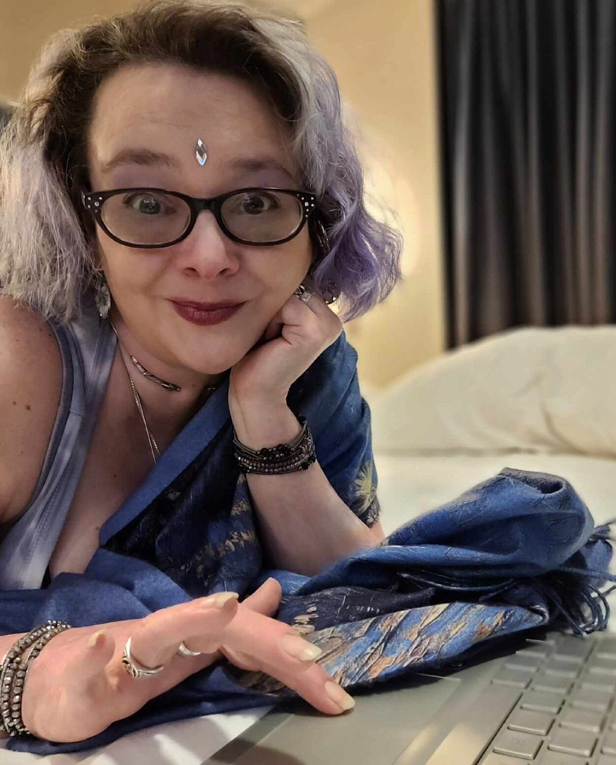 Lindsay Baldassano, a spiritual entrepreneur, at a cafe with a mocha and her laptop, working on her website. She the founder of the Mystik Web Society for spiritual small business owners, like tarot readers, reiki healers, and other types of metaphysical practitioners who need to learn the tech and strategy to make their web presence shine and make profit.